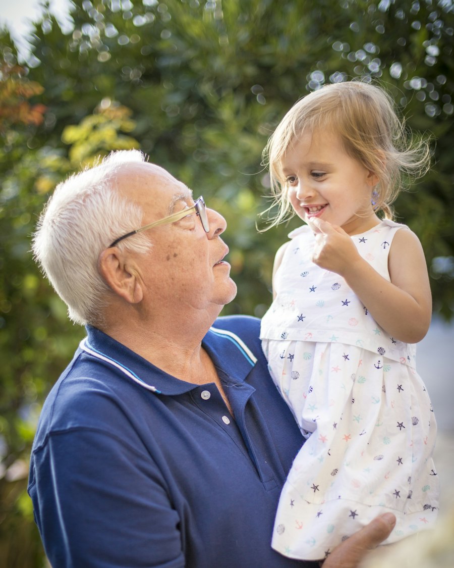 A grandfather holds his young granddaughter in a sunny garden